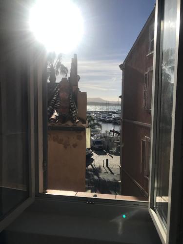 a window with a view of a harbor from a building at emplacement idéal, vue mer, parking offert in Sanary-sur-Mer