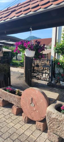 a stone bench under awning with flowers and plants at Haus Helga in Albersweiler