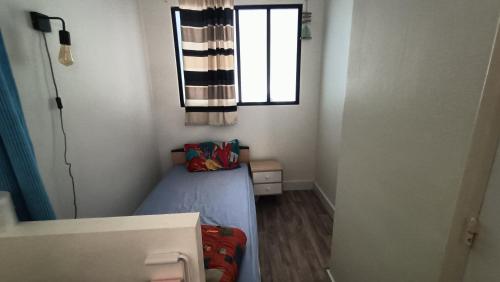 une petite chambre avec un lit et une fenêtre dans l'établissement Studio bord de mer, à Royan