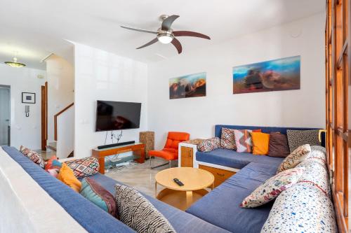 a living room with a blue couch and a tv at Hauzify I Casa Mirador 8 in L'Ametlla de Mar