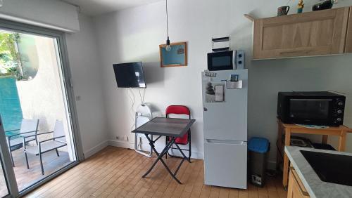 Il comprend une cuisine équipée d'une petite table et d'un réfrigérateur. dans l'établissement Studio bord de mer, à Royan