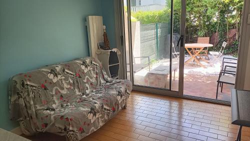 un canapé assis dans un salon à côté d'une porte coulissante en verre dans l'établissement Studio bord de mer, à Royan