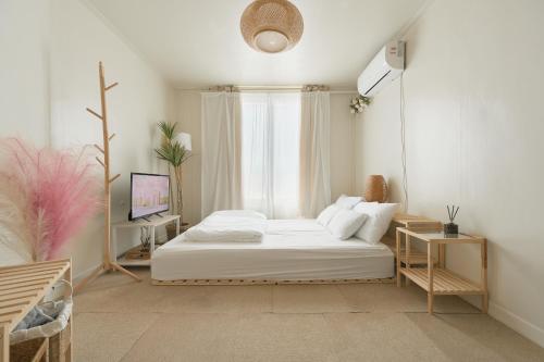 ソウルにあるSeoul Sensibility B&B Houseのベッドとテレビのある寝室