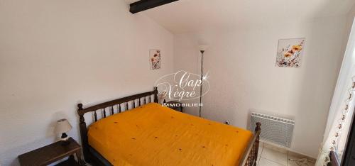 - une chambre avec un lit en bois et un panneau mural dans l'établissement Appartement 4 personnes vue mer, résidence avec piscine à Pramousquier, au Lavandou