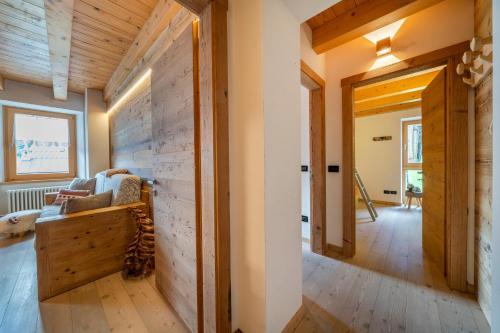 a living room with a couch and a wooden wall at GuestHost - Sappada Lovely Lodge in Sappada