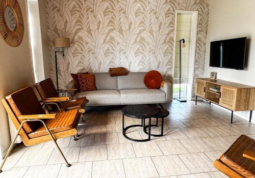 a living room with a couch and a tv at De Sloothaak in Giethoorn