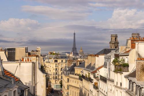 a view of the city of paris with the eiffel tower at Hotel Trianon Rive Gauche in Paris