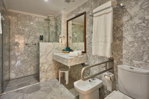 a bathroom with a shower and a toilet and a sink at Silken Gran Hotel del Sella in Ribadesella