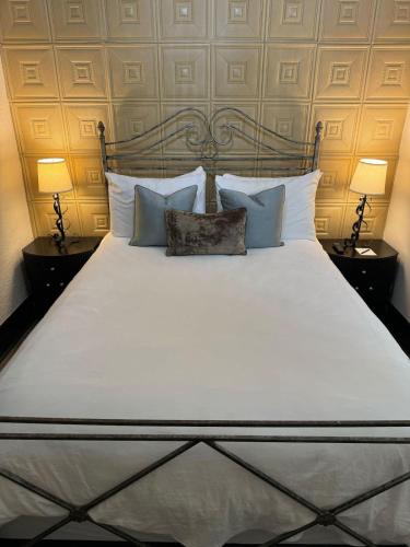 a large white bed with pillows and two lamps at The Block Basic - Queen in Bisbee