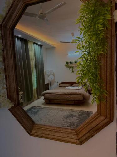 a mirror on a wall with a bed in a bedroom at Comfy heaven in Faridabad