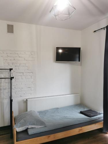 a bedroom with a bed and a tv on the wall at Stalowy Gościniec in Stalowa Wola