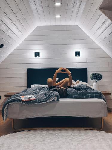 a woman laying on a bed in a bedroom at Villa Männituka in Kirikuküla