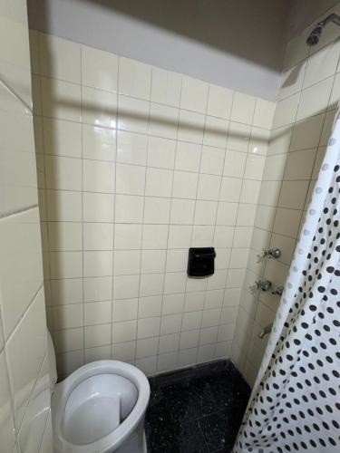 a bathroom with a toilet and a tiled wall at Jujuy Hostel in San Salvador de Jujuy