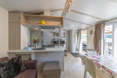 - une petite cuisine et un salon dans une petite maison dans l'établissement Mobil-home 5 pers - camping Samoens, à Samoëns