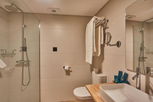 a bathroom with a shower and a toilet and a sink at Silken Gran Hotel del Sella in Ribadesella