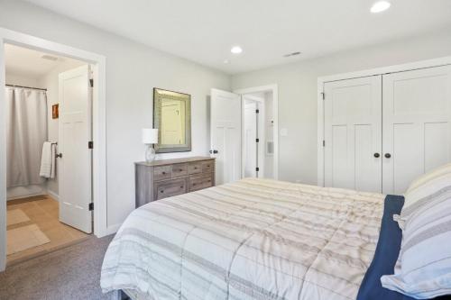 a white bedroom with a large bed and a mirror at Valley View in Basye