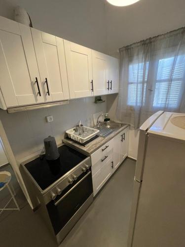 a kitchen with white cabinets and a stove top oven at Spanos Apartments - Panteli in Panteli