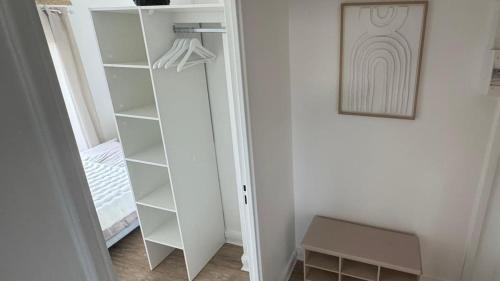 a closet with white shelves and a picture on the wall at Small Bubble in Toulouse, France T2-Parking-1KmMetro-WiFi-Cosy in Ramonville-Saint-Agne