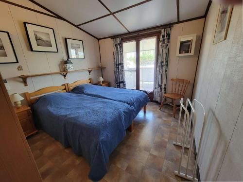 une chambre avec un lit avec une couverture bleue dans l'établissement Belle villa d'angle climatisée dans domaine de vacances PORTES DU SOLEIL, 3 chambres, 6 couchages, fibre Wifi, à PORTIRAGNES PLAGE LRPDSH5, à Portiragnes