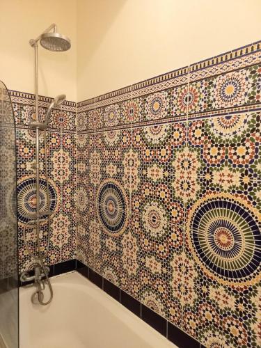 La salle de bains est pourvue d'une baignoire et d'un mur carrelé. dans l'établissement Bohemian Break with Balcony overlooking Mont Saint Clair, à Sète