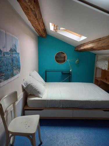 une petite chambre avec un lit et une chaise dans l'établissement Bohemian Break with Balcony overlooking Mont Saint Clair, à Sète