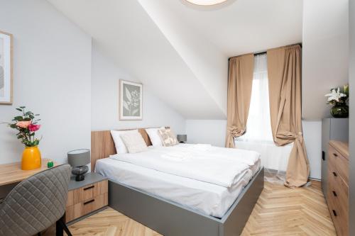 a bedroom with a bed and a desk and a window at Nowy Hotel Monika - by Upstairs in Kraków