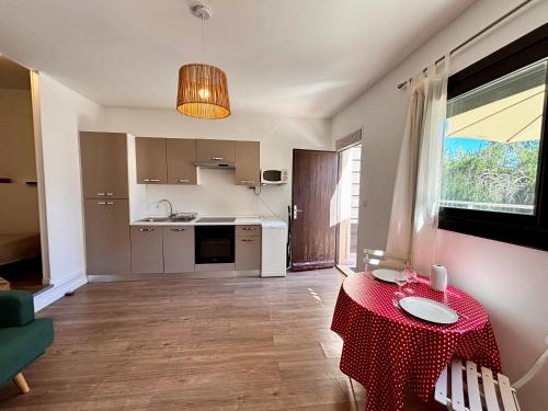 un salon avec une table et une cuisine dans l'établissement Casamea - Studio, Terrasse, 5 min plage, Clim, à Ajaccio