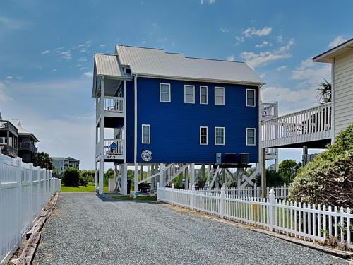 een blauw huis aan de zijkant van een wit hek bij Otter Oasis in Surf City