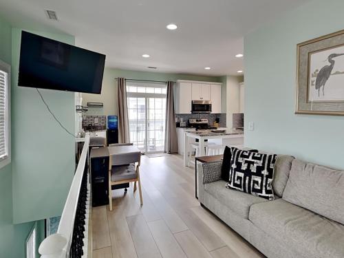 a living room with a couch and a kitchen at Otter Oasis in Surf City