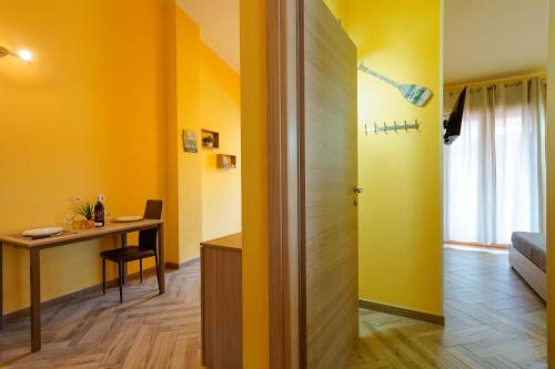 a room with yellow walls and a desk and a door at Paradise Home in Quartu SantʼElena