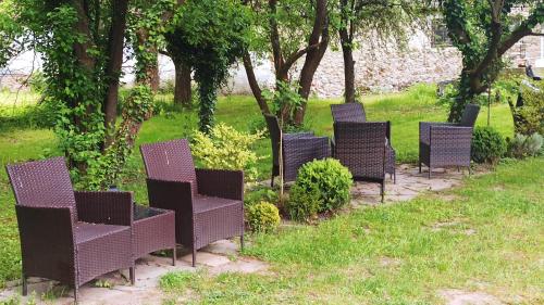 a row of wicker chairs sitting in the grass at Penzion U kostela Mláka in Mláka