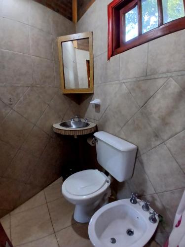 a bathroom with a toilet and a sink at Cabañas Costa Santino in Ituzaingó