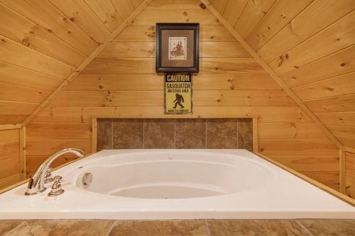 una bañera en una habitación con techo de madera en Bigfoot Bungalow, free tickets, no catch!, en Pigeon Forge