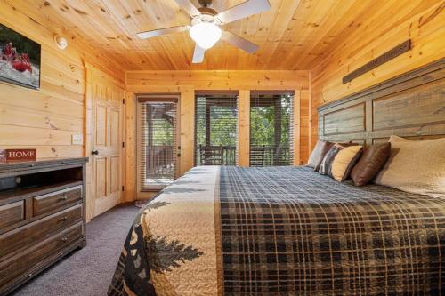 Un dormitorio con una cama y un ventilador de techo. en Bigfoot Bungalow, free tickets, no catch!, en Pigeon Forge