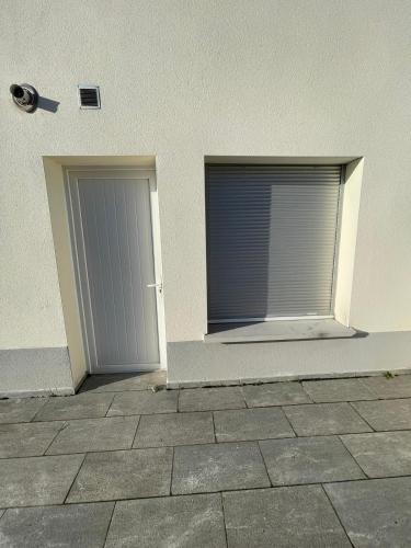 Deux portes de garage sur le côté d'un bâtiment dans l'établissement Studio L'Olivier 1 St Priest -Proche Université Lyon 2, à Saint-Priest