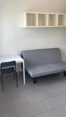 un canapé assis à côté d'une table et une table et une table et une chaise dans l'établissement Studio L'Olivier 1 St Priest -Proche Université Lyon 2, à Saint-Priest