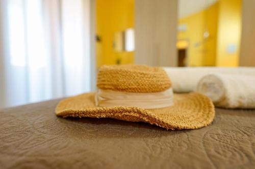 a straw hat sitting on top of a bed at Paradise Home in Quartu SantʼElena