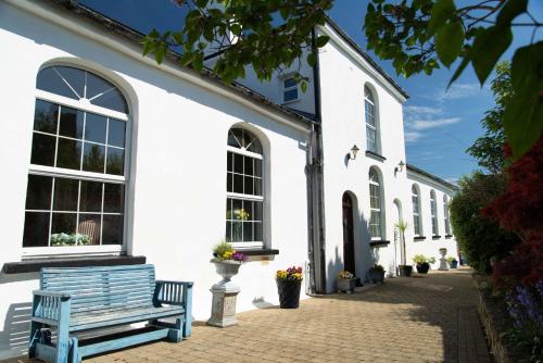 a white building with a blue bench in front of it at The Classroom, Patricks Square, Wexford Town in Wexford