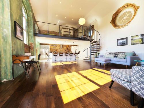 a living room with a spiral staircase and a living room at The Classroom, Patricks Square, Wexford Town in Wexford