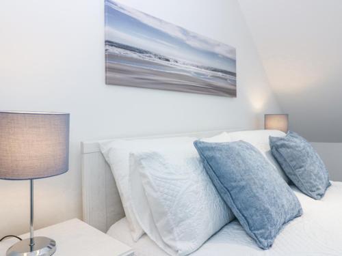 a bed with two pillows and a painting on the wall at Sea Breeze St Combs in Fraserburgh