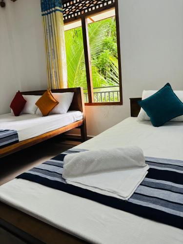 two beds in a room with a window at Madiriya Forest Lodge Apartment in Badulla