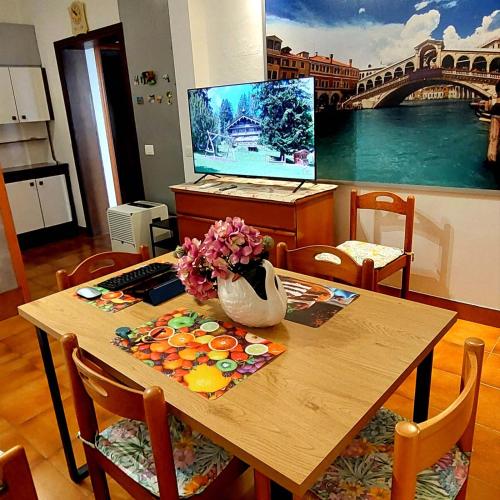 Una mesa de madera con un jarrón de flores encima. en Hotspot Venice EL FULVIA, en Carpenedo
