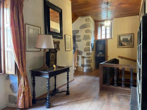 a room with a table with a lamp on it at Château du Bouy in Champétières