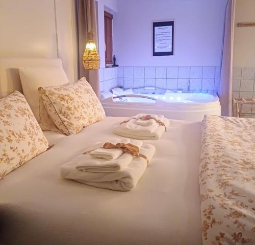 - 2 serviettes sur un lit avec baignoire dans l'établissement L'instant Beaujolais 2 ou 4 personnes Logis cosy balnéo vue jardin, à Theizé