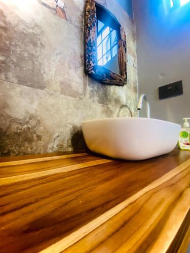 a bathroom with a large white tub on a wooden counter at Lucky Monkey Lodge in Arusha