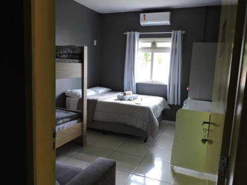 a bedroom with two bunk beds and a window at Pousada Portal Pomerode in Pomerode