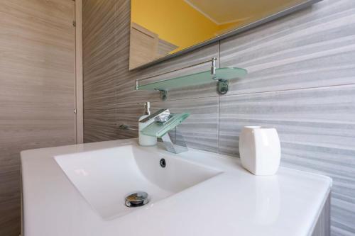 a bathroom with a white sink and a mirror at Paradise Home in Quartu SantʼElena