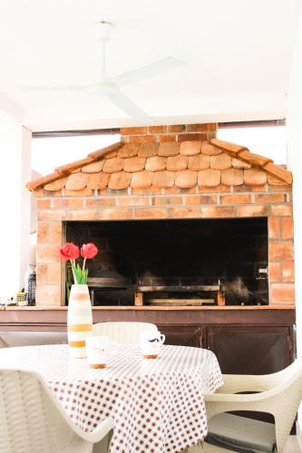 a table with a vase of flowers and a fireplace at Drina River Retreat in Novo Selo