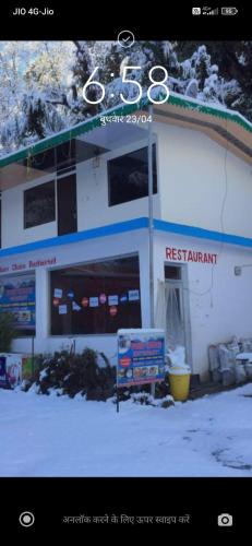 a sign in the snow in front of a building at Hotel your choice in Ukhimath