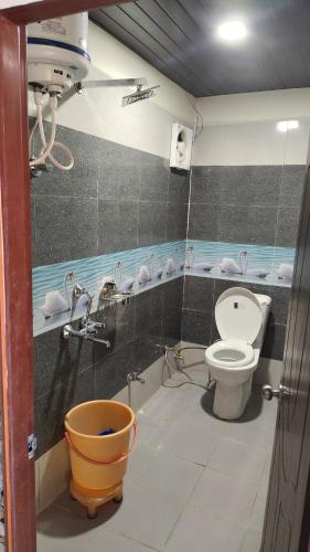 a bathroom with a toilet and faucet at Hotel your choice in Ukhimath